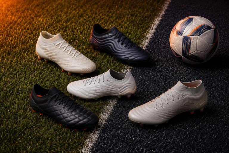 Different football boots on grass and artificial turf